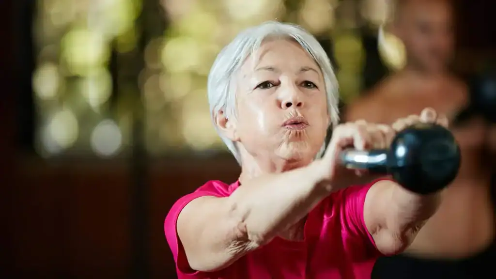 Older woman doing weight training Leicestershire to help her strength and longevity 