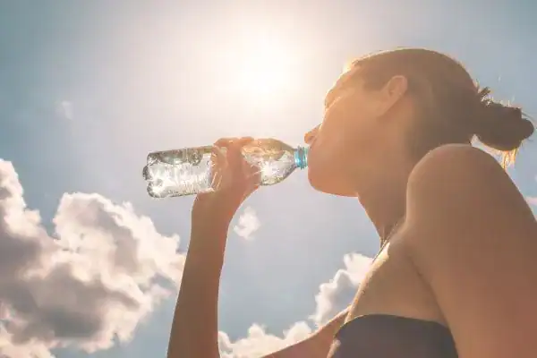 Hydration: The Secret Ingredient for a Toned Stomach and Enhanced Fitness 3 Image of woman drinking water to hydrate Leicestershire after run.
